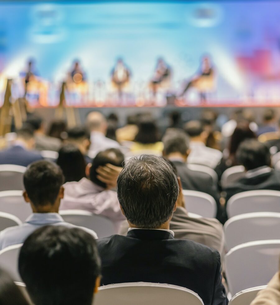 rear-view-of-audience-listening-speakers-on-the-stage-in-the-conference-hall-or-seminar-meeting.jpg
